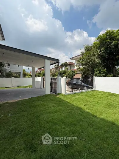 Charming suburban home with lush green lawn and secure gated driveway.