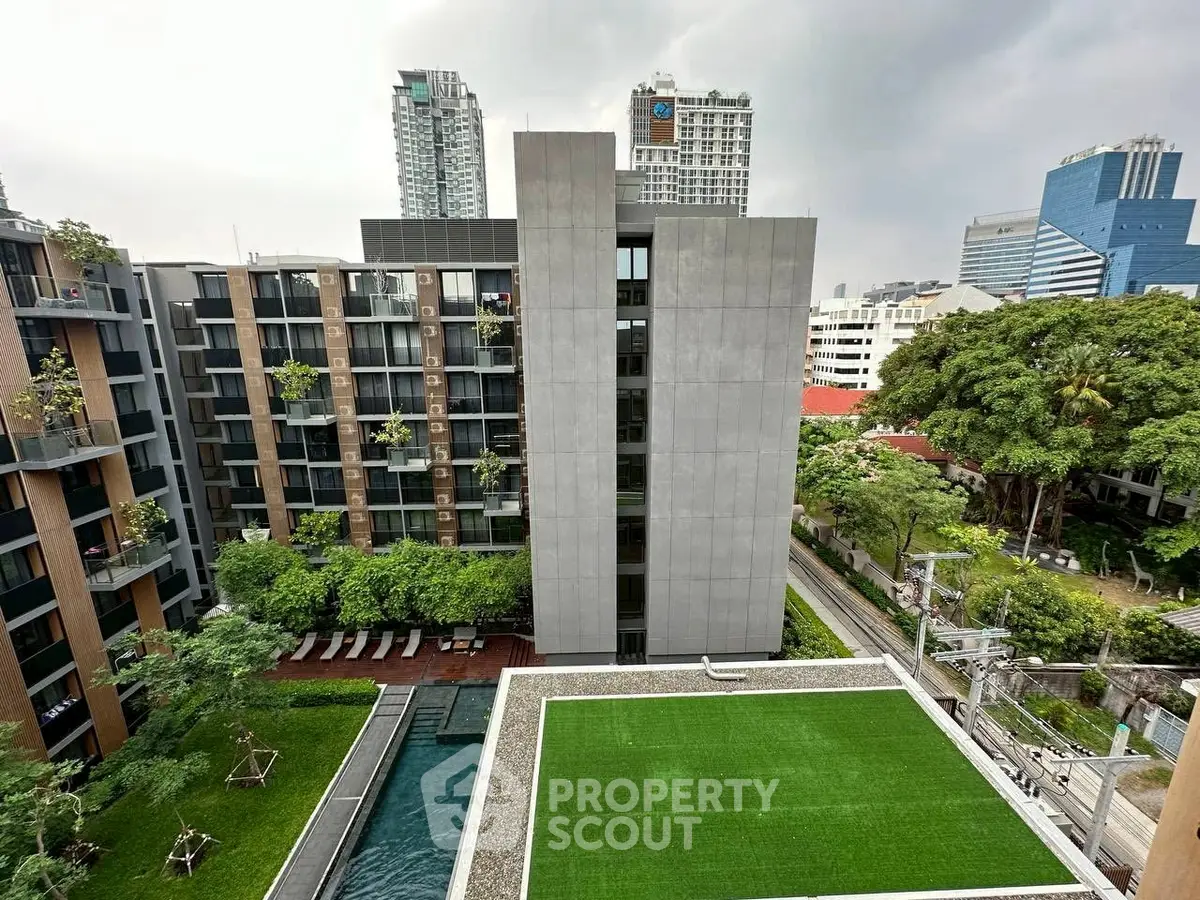 Modern urban apartment complex with pool and green rooftop garden