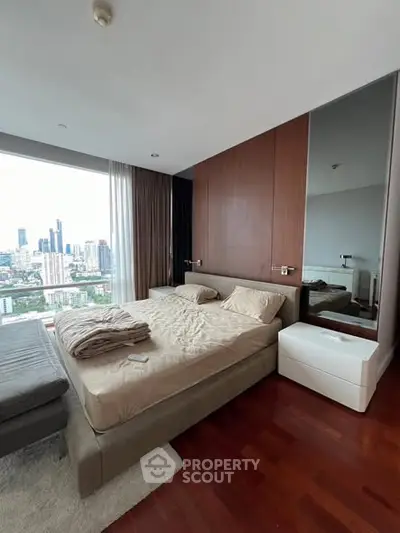Luxurious bedroom with stunning city view and elegant wooden flooring.