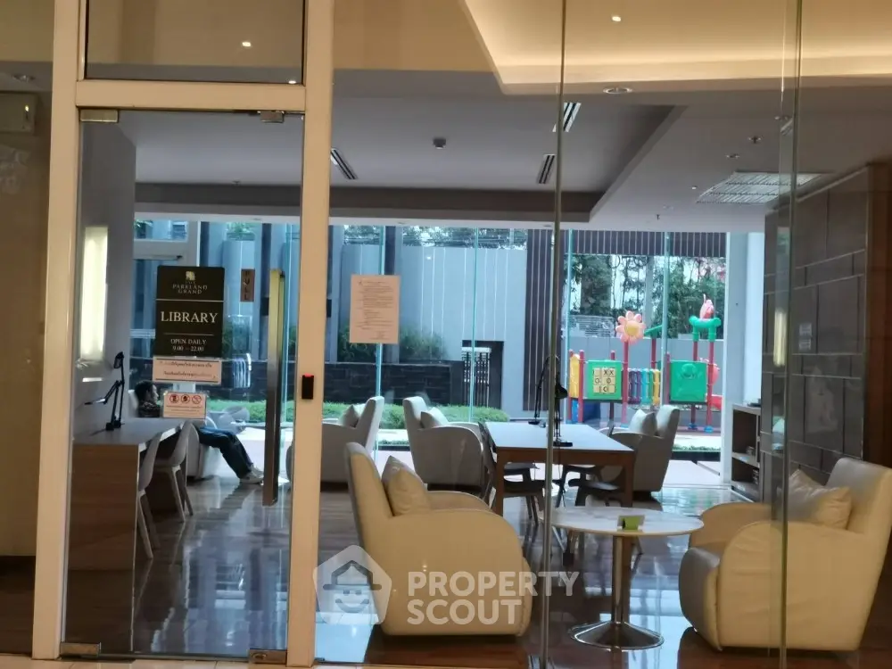 Modern library with glass walls and comfortable seating in a residential complex
