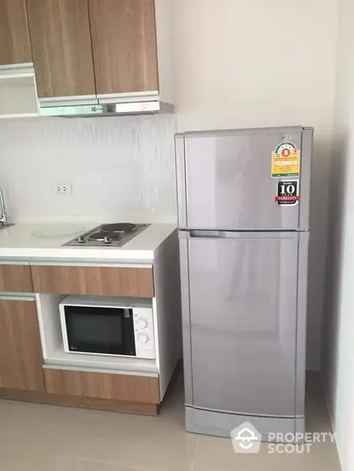 Modern kitchen with sleek fridge and built-in microwave in stylish apartment