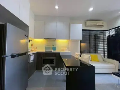 Modern kitchen with sleek design, open layout, and cozy living area featuring stylish furniture and bright lighting.