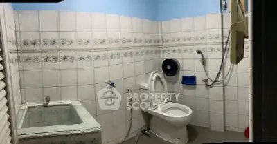 Spacious bathroom with bathtub and modern fixtures in a tiled setting.