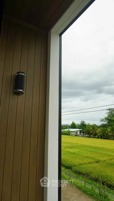 Stunning balcony view overlooking lush green fields and serene countryside.