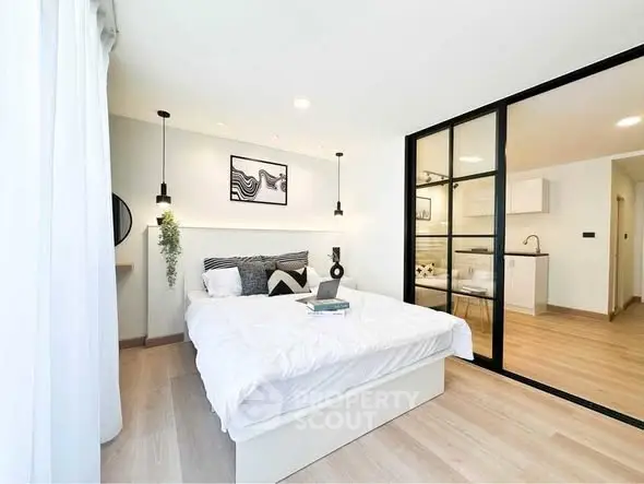 Modern bedroom with stylish decor and open layout to kitchen area.
