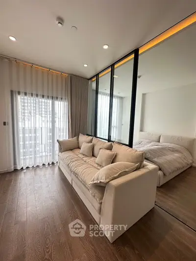Modern bedroom with elegant decor and floor-to-ceiling windows for natural light.