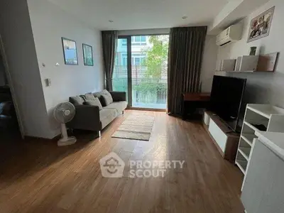Spacious living room with modern decor and large window offering natural light.