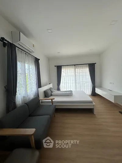 Spacious bedroom with modern decor and natural light