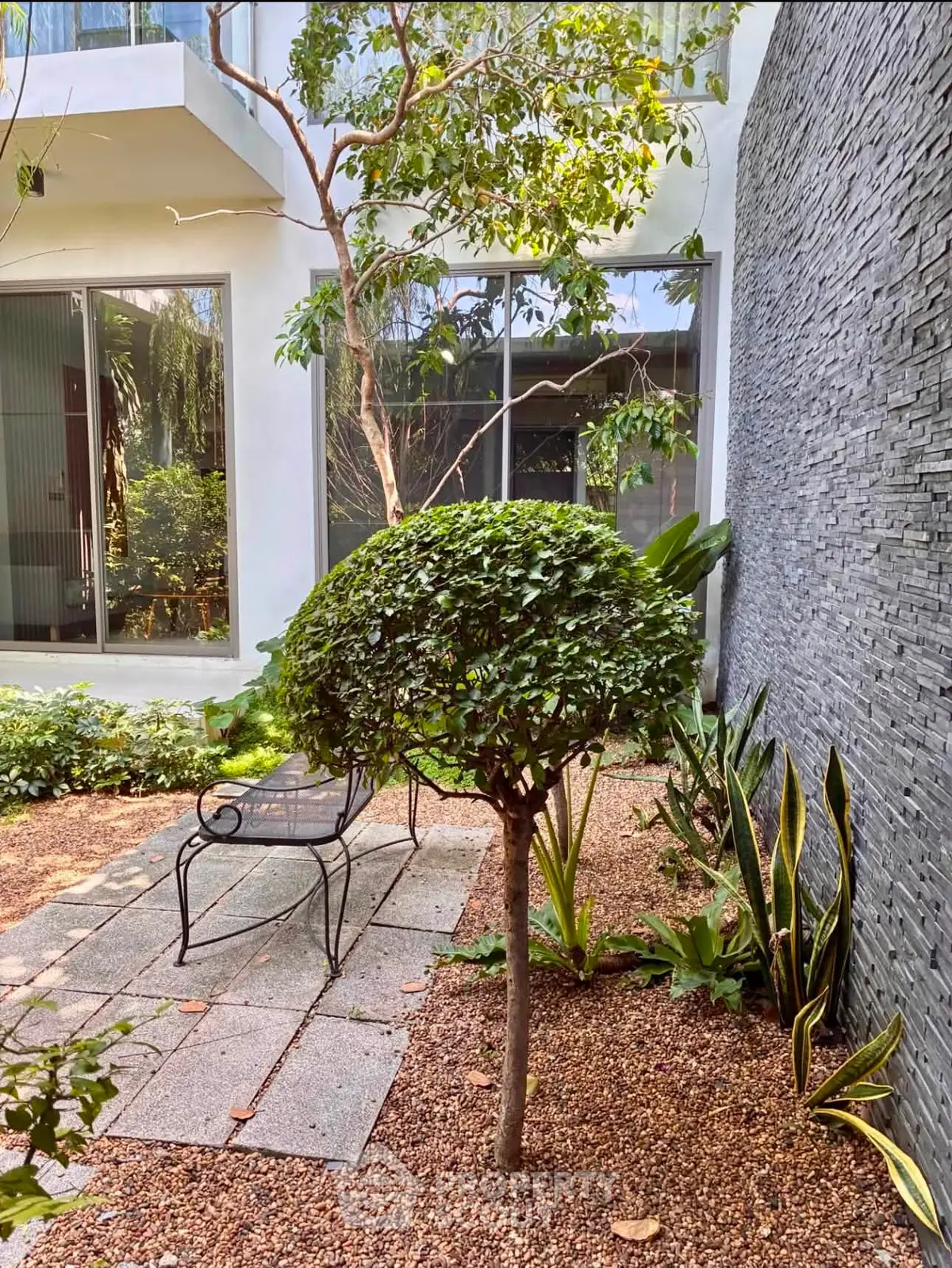 Charming garden patio with lush greenery and modern design elements for serene outdoor living.