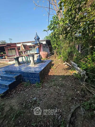Charming rural property with traditional outdoor shrine and lush greenery, perfect for serene living.