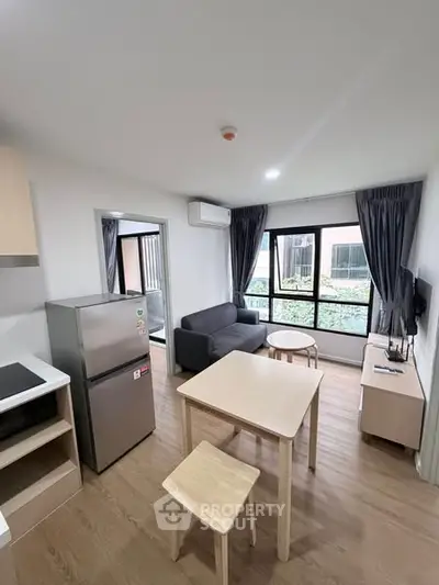 Modern living room with sleek furniture and large windows in a cozy apartment.