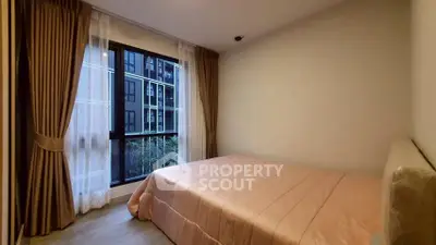 Cozy bedroom with large window and elegant curtains in modern apartment