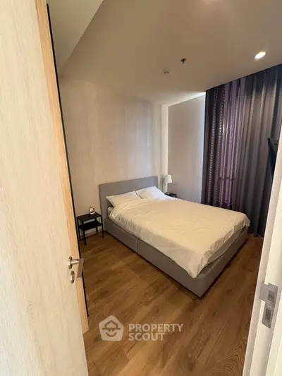 Modern bedroom with wooden flooring and cozy bed in a stylish apartment