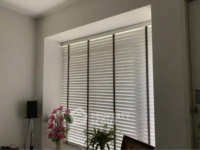 Cozy interior with window blinds and decorative plants in a modern living space.