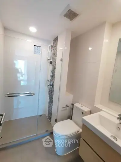 Modern bathroom with glass shower enclosure and sleek fixtures