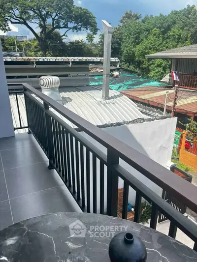 Charming balcony view with modern railing and lush greenery, perfect for relaxation.