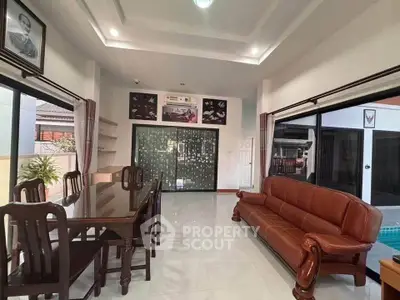 Spacious living room with elegant furniture and pool view, perfect for family gatherings.