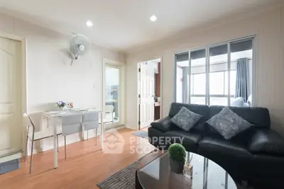 Modern living room with stylish decor and natural light, featuring a cozy seating area and dining space.