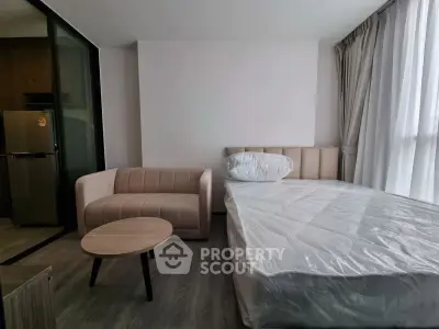 Modern studio apartment with cozy bed and stylish sofa in open layout.