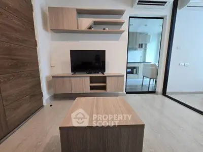 Modern living room with sleek wooden furniture and open kitchen view