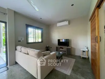 Cozy living room with modern decor and air conditioning, perfect for relaxation.
