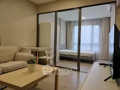 Modern studio apartment with glass partition, cozy living area, and natural light.