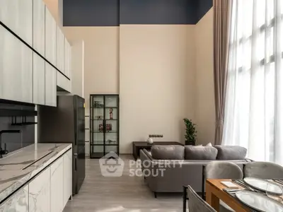 Modern open-plan living room with high ceilings and stylish kitchen