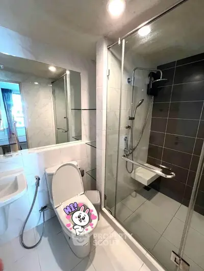 Modern bathroom with glass shower and sleek fixtures in a contemporary apartment.
