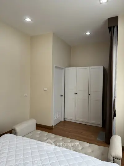 Cozy bedroom with elegant white wardrobe and soft lighting