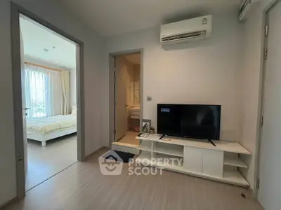 Modern apartment interior with bedroom and living area featuring air conditioning and TV setup.