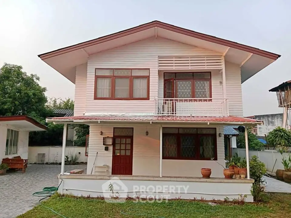 Charming two-story house with a spacious front yard and classic architectural design.