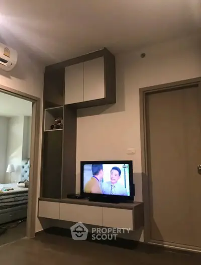Modern living room with sleek TV cabinet and air conditioning, showcasing stylish interior design.