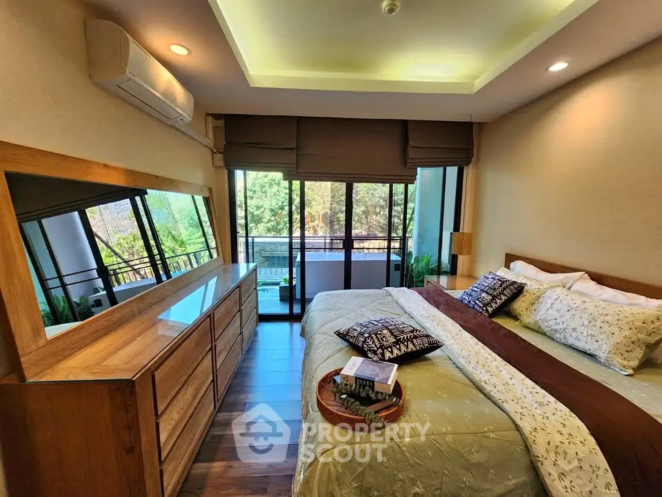 Luxurious bedroom with balcony view and elegant wooden furniture.