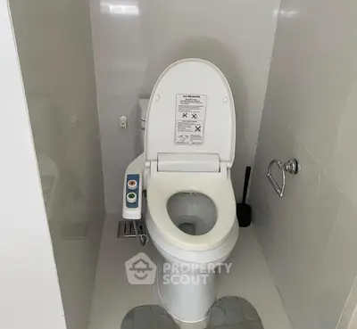 Modern bathroom with advanced toilet featuring control panel and sleek design.