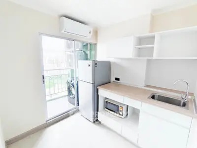Modern kitchen with balcony access, featuring sleek appliances and ample storage in a bright, airy space.
