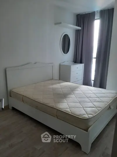 Spacious bedroom with natural light, featuring a comfortable bed and modern decor.