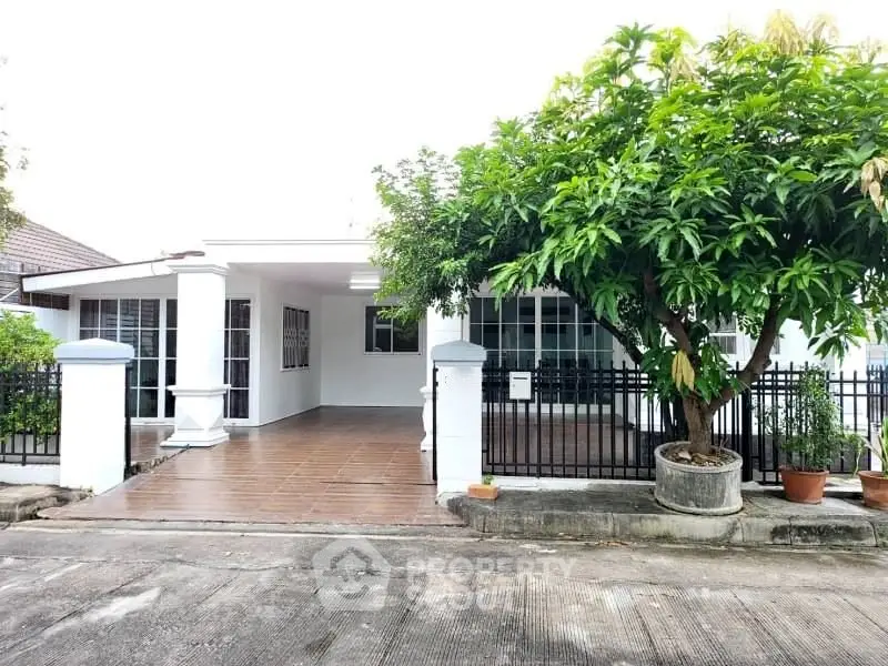 Charming single-story house with spacious driveway and lush garden.