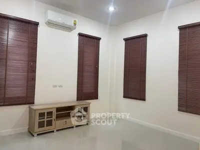 Spacious living room with modern air conditioning and elegant wooden blinds, perfect for cozy gatherings.