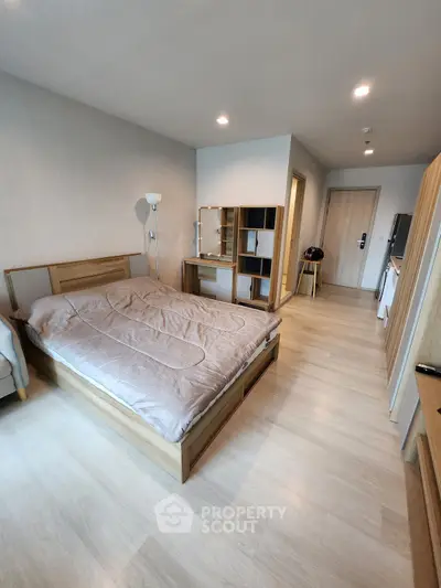 Modern bedroom with wooden furniture and cozy decor in a stylish apartment.