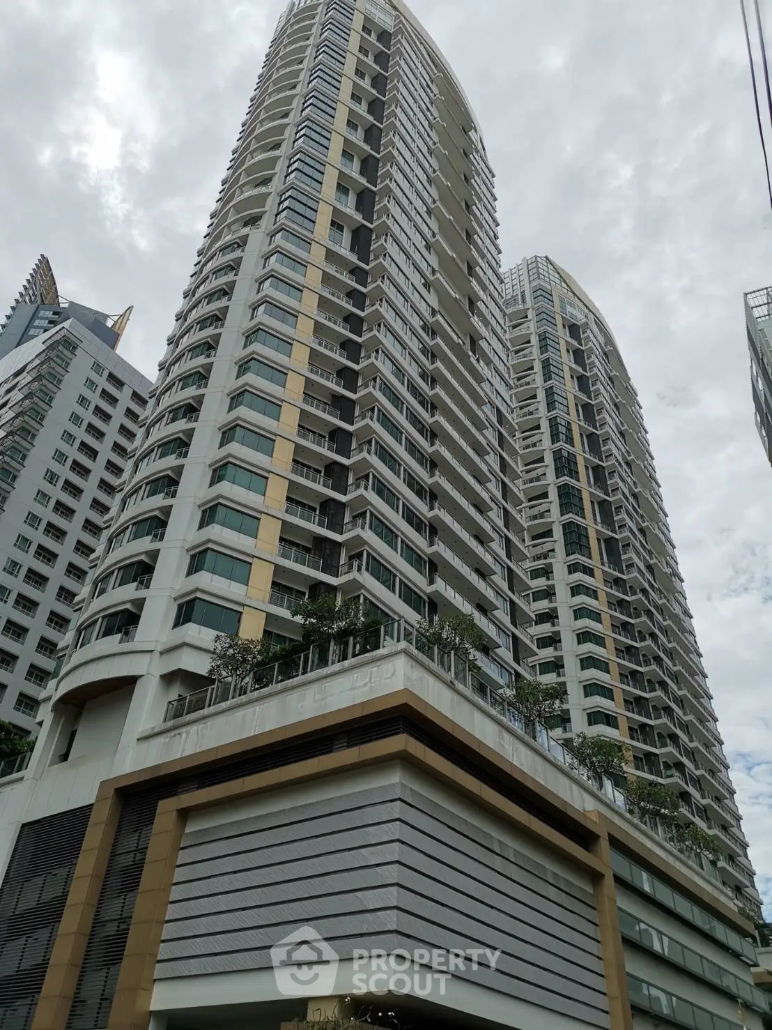 Stunning high-rise residential building with modern architecture and expansive balconies in urban setting.