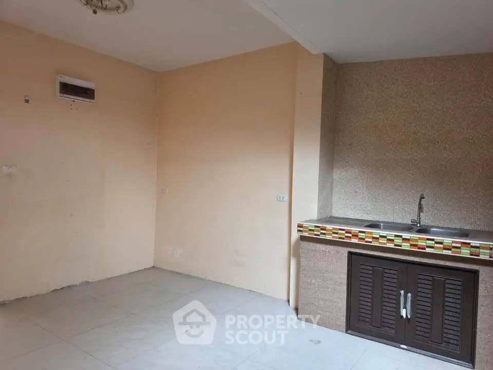 Spacious kitchen area with dual sink and tiled backsplash in a minimalist design.