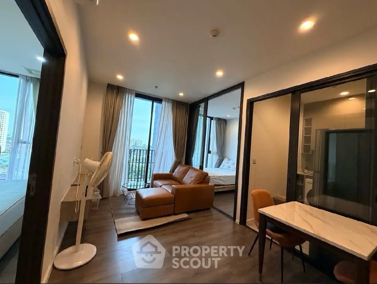 Modern apartment with cozy living room and city view, featuring stylish furniture and natural light.