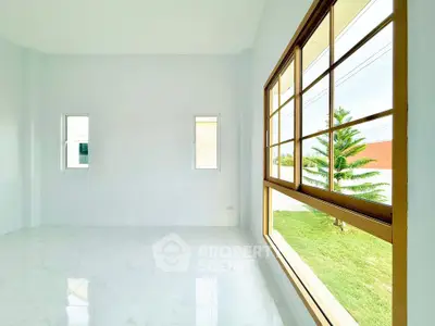 Spacious bright room with large windows overlooking a lush garden, perfect for natural light lovers.