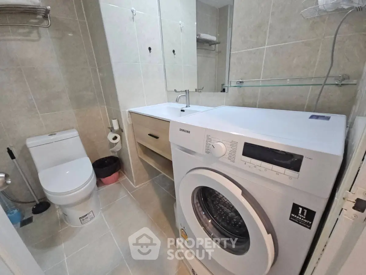 Compact bathroom with washing machine and modern fixtures