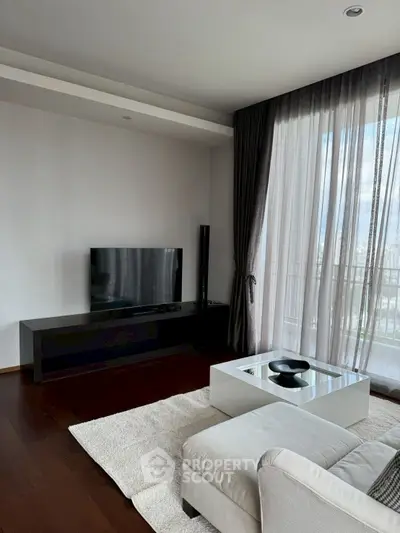 Modern living room with sleek TV setup and large window view