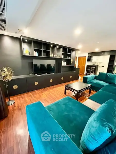 Spacious living room with teal sofas and modern entertainment unit