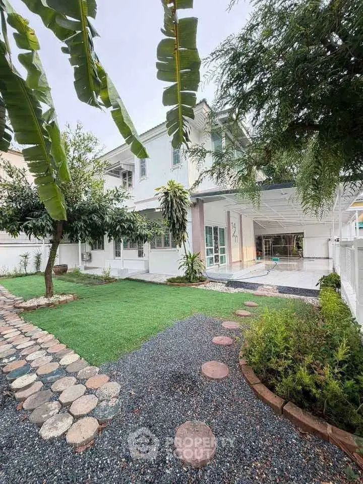 Charming two-story house with lush garden and modern exterior design