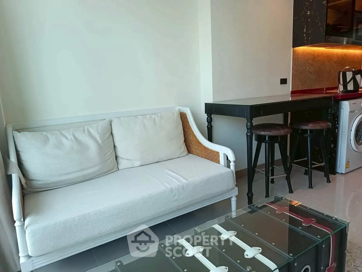 Modern living room with stylish sofa and bar counter, featuring a washing machine and chic decor.