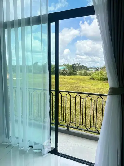Stunning view from a modern balcony with lush greenery and blue skies.