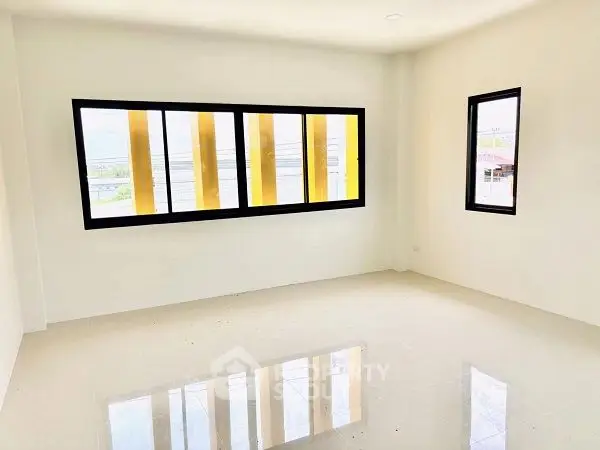 Bright empty room with large windows and glossy floor, perfect for customization.